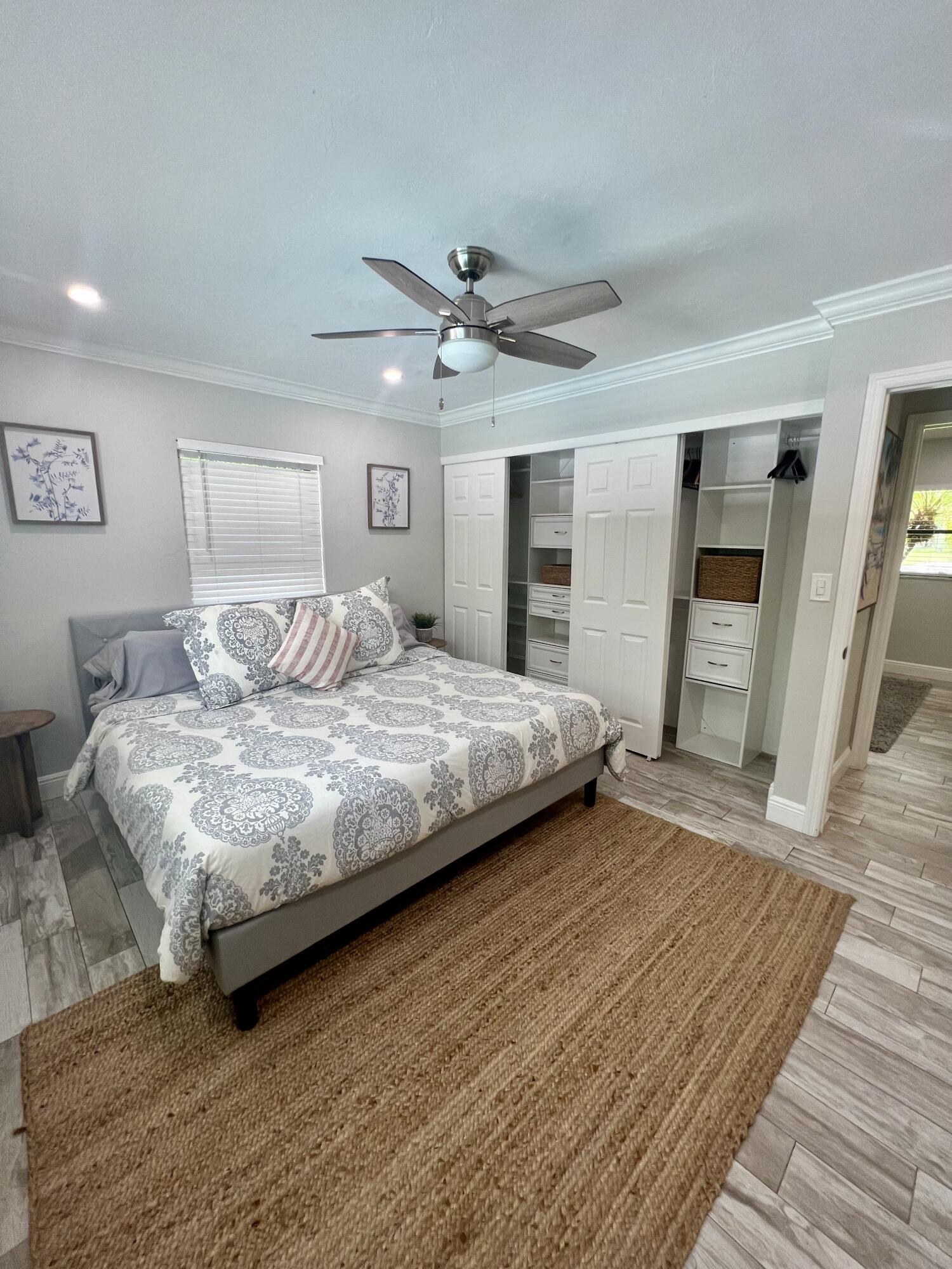 115 Northeast 18th Street Delray Beach, FL 33444 - Photo 14 of 36 a bedroom with a large bed and wooden floor