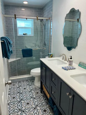 a bathroom with a sink a toilet and shower