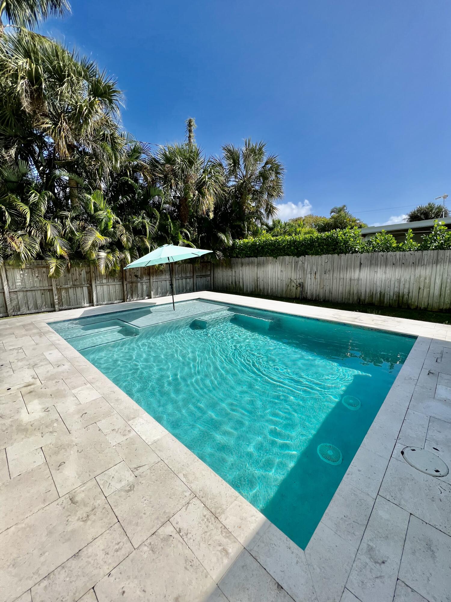 115 Northeast 18th Street Delray Beach, FL 33444 - Photo 25 of 36 a swimming pool with trees in the background