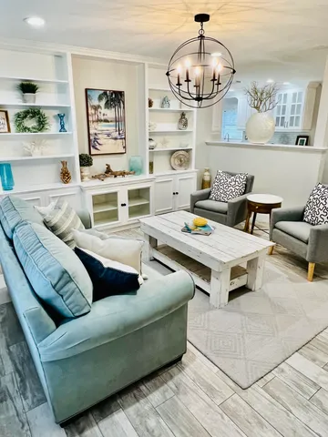 a living room with furniture and a chandelier