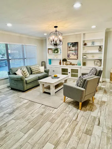 a living room with furniture and a chandelier
