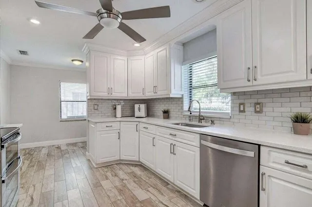 a kitchen with a sink window and cabinets