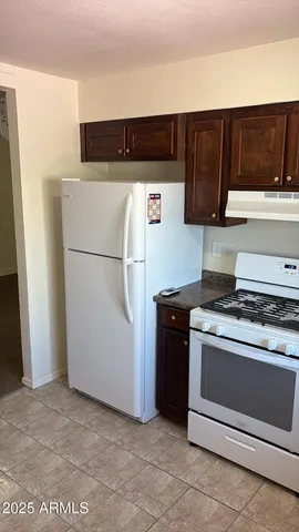 a kitchen with stainless steel appliances granite countertop a refrigerator stove a sink and dishwasher