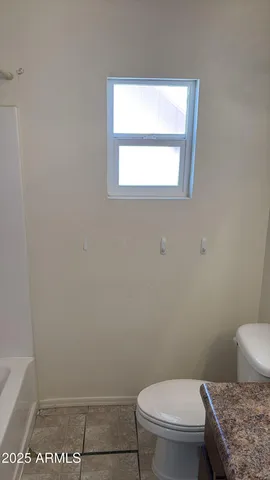 a white toilet sitting next to a window