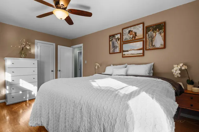 a kitchen with stainless steel appliances granite countertop a refrigerator a sink dishwasher a stove and white cabinets with wooden floor