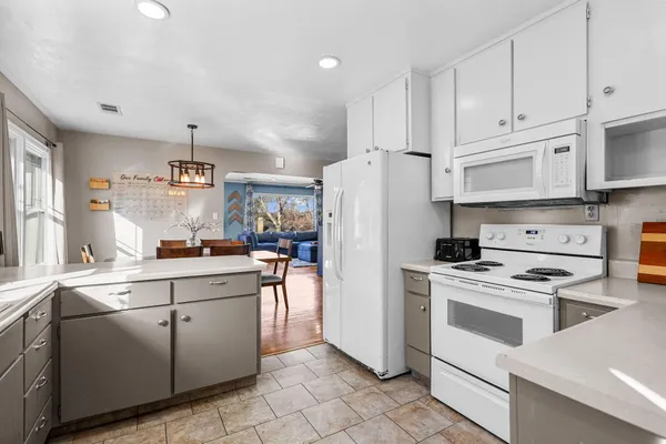 a kitchen with white cabinets and white appliances