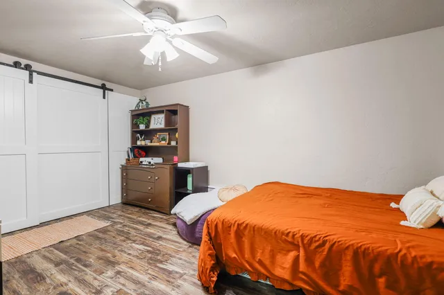 a bedroom with furniture and a wooden floor