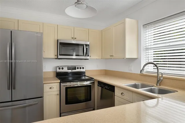 a kitchen with stainless steel appliances a stove a sink a microwave and cabinets