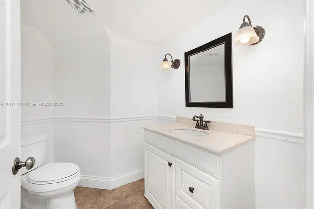 a bathroom with a sink toilet and mirror