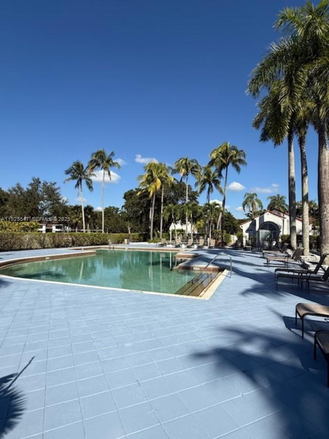 921 Lyons Road, Unit 3205 Coconut Creek, FL 33063 - Photo 28 of 37 a view of a swimming pool with a table and chairs