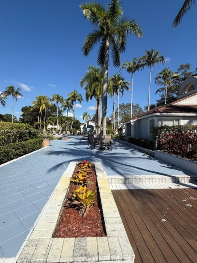 921 Lyons Road, Unit 3205 Coconut Creek, FL 33063 - Photo 29 of 37 a view of a swimming pool with a table and chairs