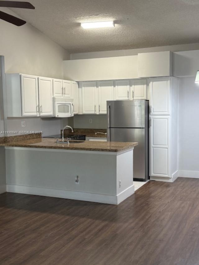 921 Lyons Road, Unit 3205 Coconut Creek, FL 33063 - Photo 6 of 37 a kitchen with a refrigerator and white cabinets
