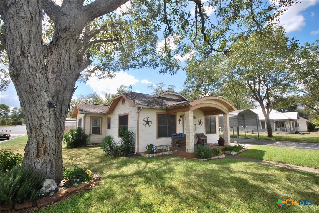 302 South Main Street Schulenburg, TX 78956 - Photo 1 of 39 a front view of a house with a garden and trees