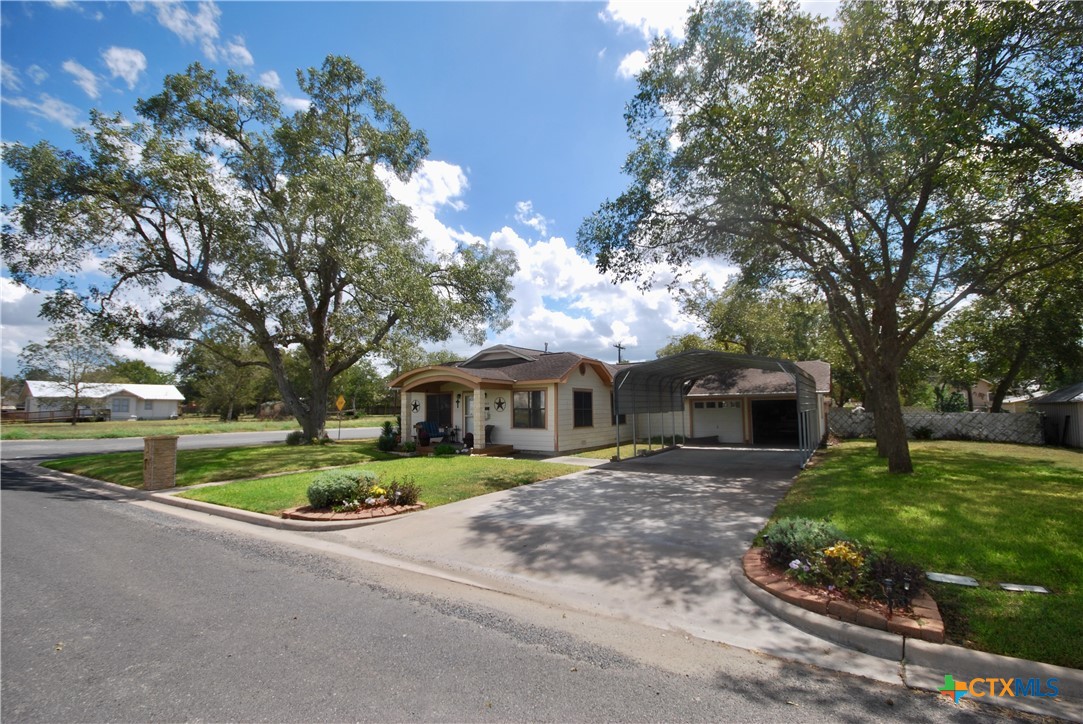 302 South Main Street Schulenburg, TX 78956 - Photo 35 of 39 a front view of a house with a yard garage and outdoor seating