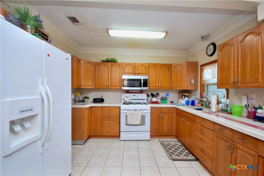 302 South Main Street Schulenburg, TX 78956 - Photo 7 of 39 a kitchen with a stove top oven sink and cabinets