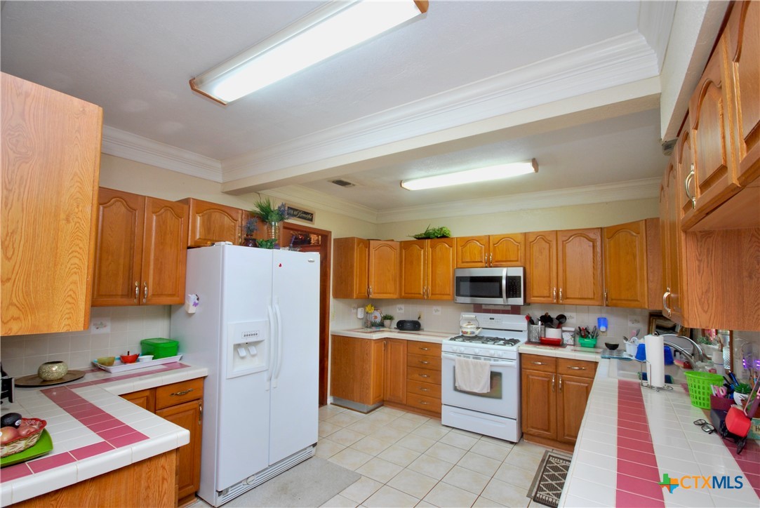 302 South Main Street Schulenburg, TX 78956 - Photo 8 of 39 a kitchen with stainless steel appliances granite countertop a refrigerator stove and a sink