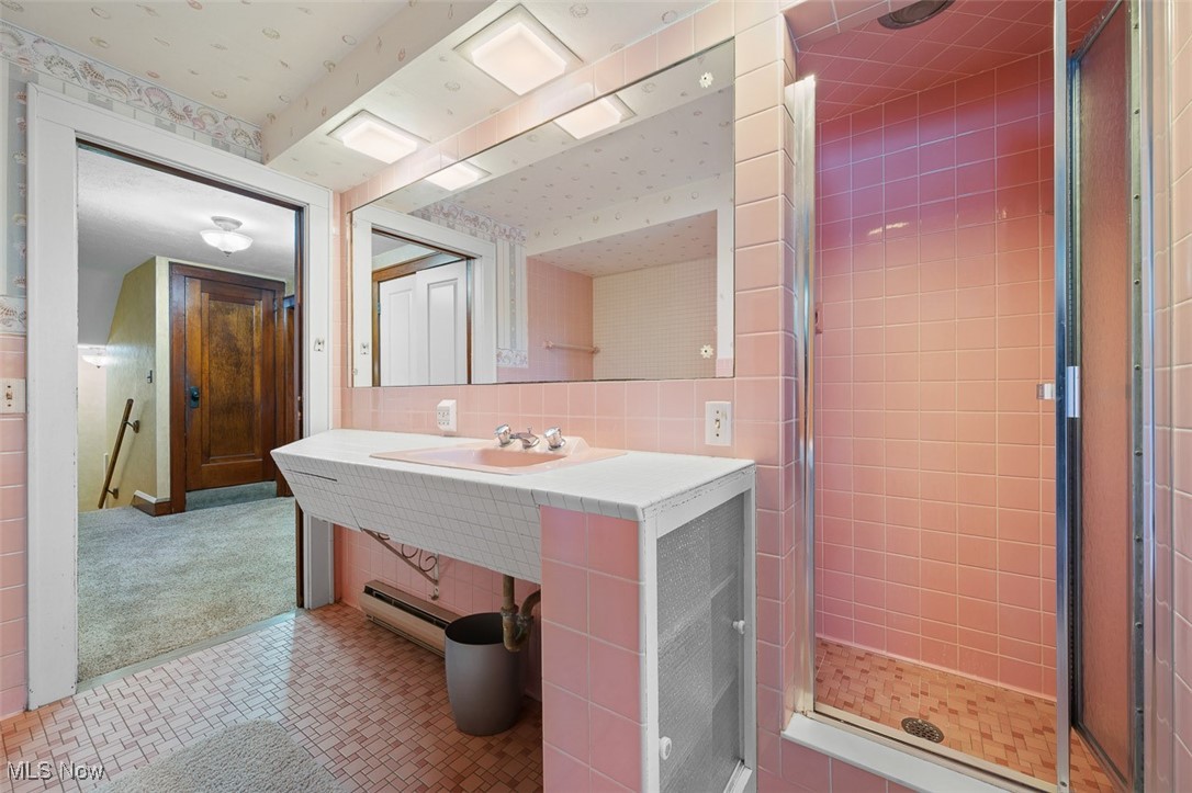 256 Everhard Road Southwest North Canton, OH 44709 - Photo 26 of 45 Bathroom with a shower stall, tile walls, a baseboard heating unit, and tile patterned floors
