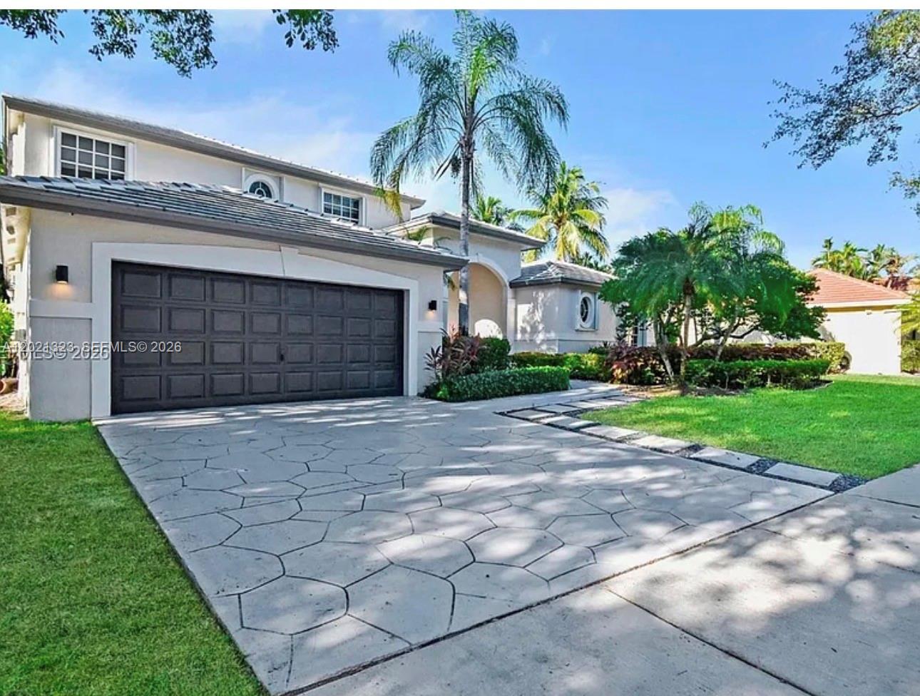354 Mallard Road, Unit O Weston, FL 33327 - Photo 26 of 29 a front view of a house with a yard and garage