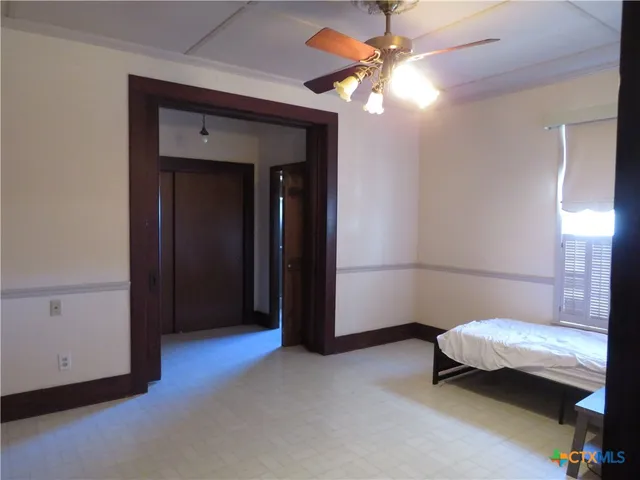 a bedroom with a bed and a ceiling fan