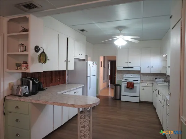 a kitchen with refrigerator and cabinets