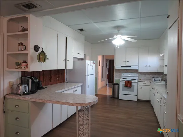 a kitchen with refrigerator and cabinets