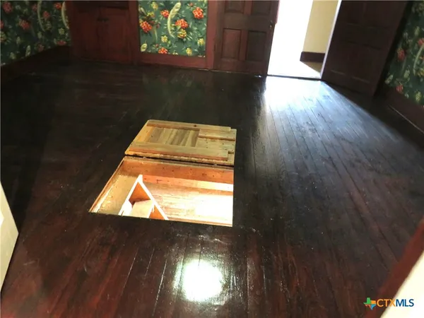 view of an empty room with wooden floor and a window