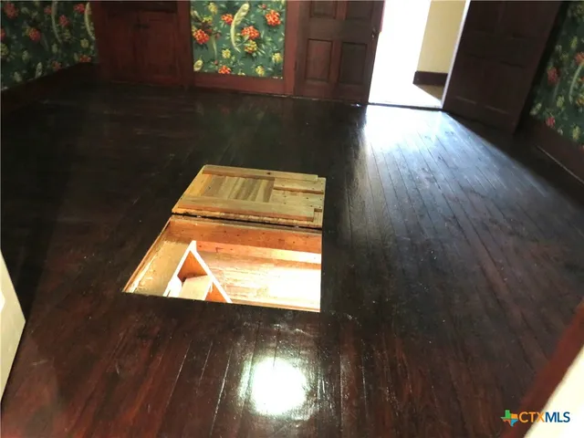 view of an empty room with wooden floor and a window
