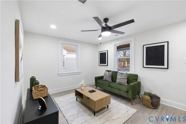 a living room with furniture and a wooden floor