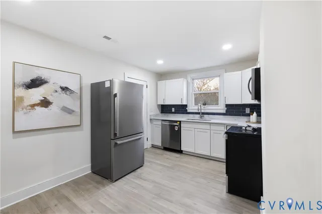 a kitchen with stainless steel appliances granite countertop a sink stove and cabinets