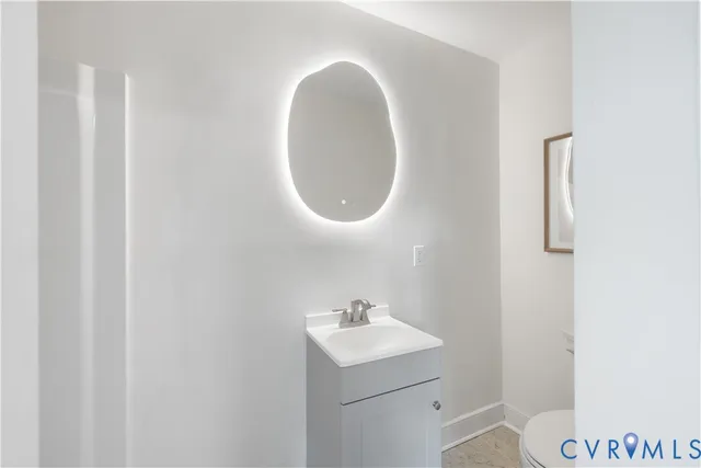 a bathroom with a toilet a sink and mirror