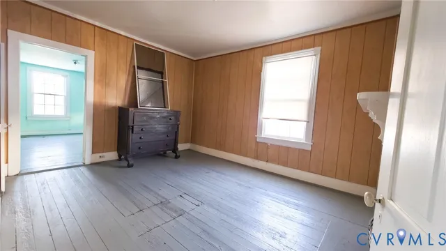 a view of empty room with window and wooden floor