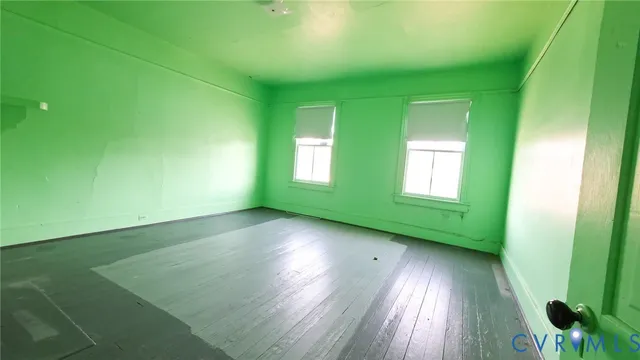 an empty room with wooden floor and fireplace