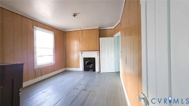 a view of a livingroom with wooden floor and a fireplace