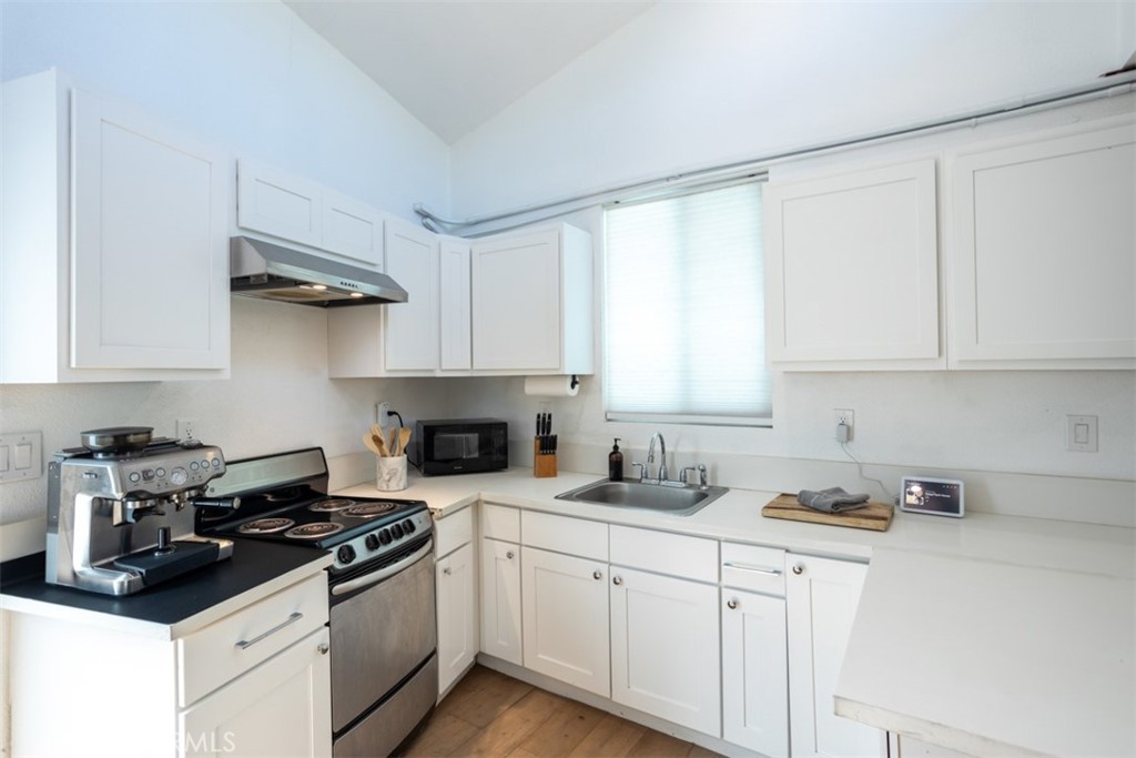 950 El Paso Drive Los Angeles, CA 90042 - Photo 46 of 52 a kitchen with stainless steel appliances granite countertop white cabinets sink and stove