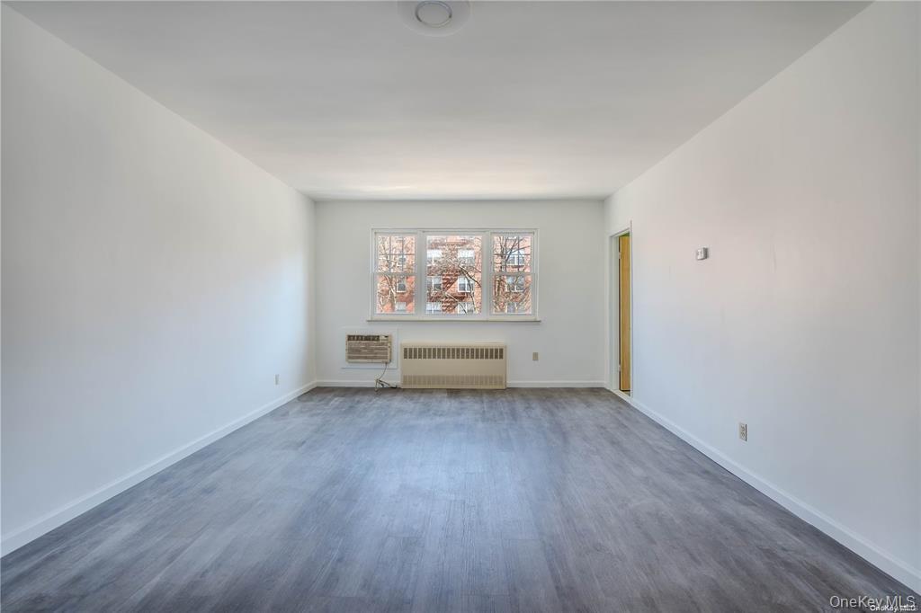 79-18 150th Street, Unit 3 Queens, NY 11367 - Photo 3 of 10 an empty room with wooden floor and windows