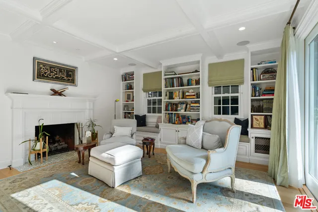 a living room with furniture hard wood floor and a book shelf