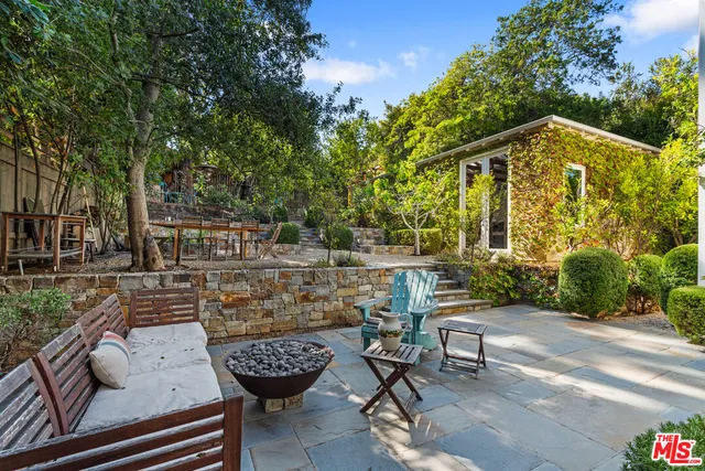 a view of backyard with table and chairs and potted plants
