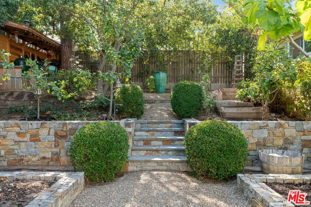 a view of a patio with table and chairs and wooden fence