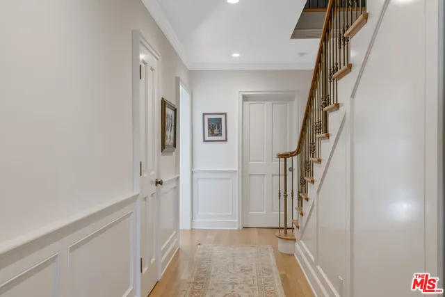 a view of hallway with stairs and wooden floor