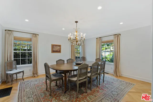 a dining room with furniture a rug and a chandelier