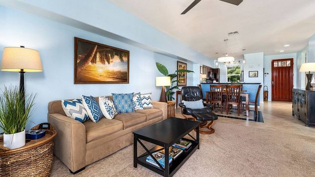 a living room with furniture a fireplace and a chandelier