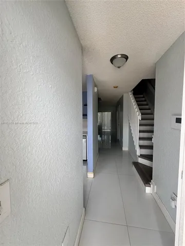 a view of a hallway with entryway and stairs