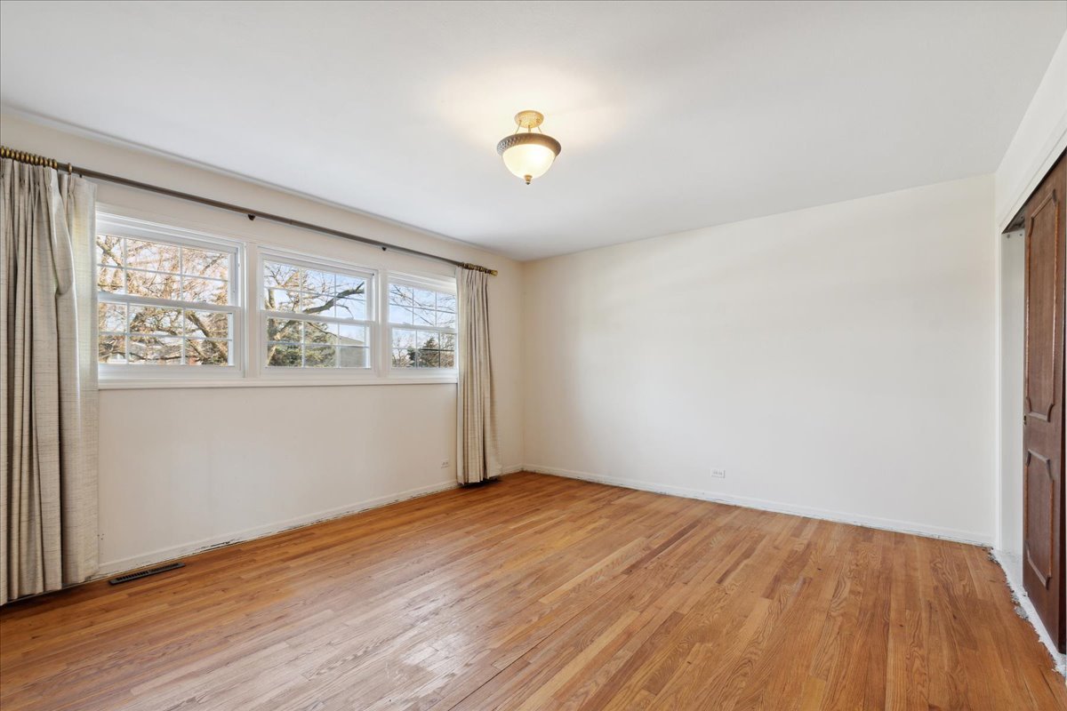 962 Suffield Terrace Northbrook, IL 60062 - Photo 12 of 33 an empty room with wooden floor and windows