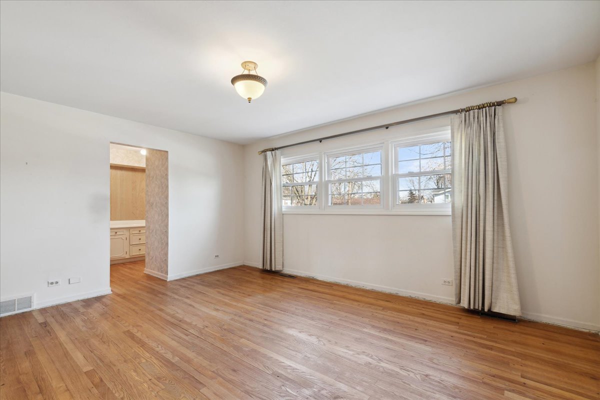 962 Suffield Terrace Northbrook, IL 60062 - Photo 13 of 33 an empty room with wooden floor and windows