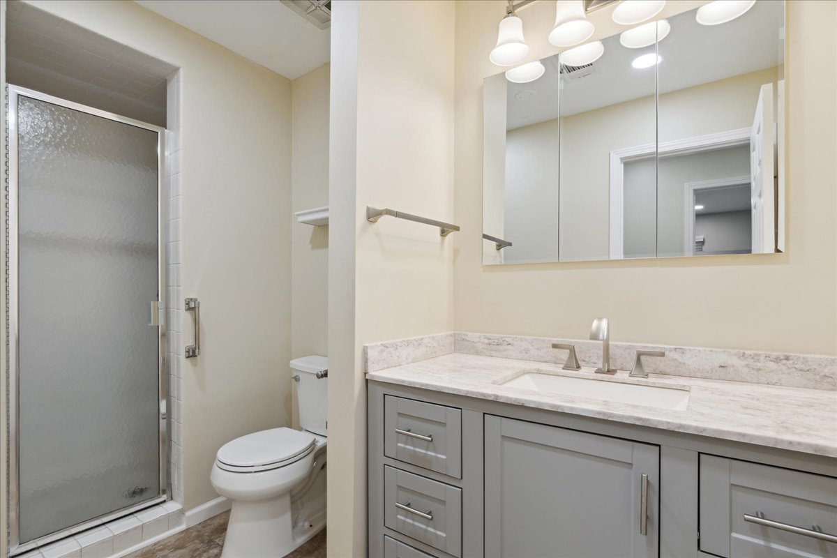 962 Suffield Terrace Northbrook, IL 60062 - Photo 20 of 33 a bathroom with a granite countertop sink a toilet and a mirror