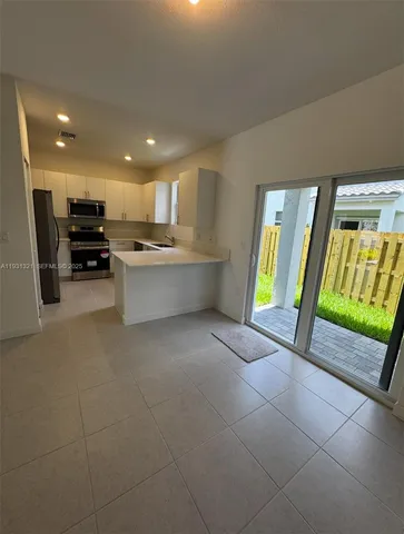 a large kitchen with stainless steel appliances a refrigerator and a sink