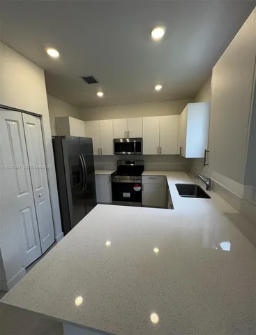 an empty room with windows and fireplace