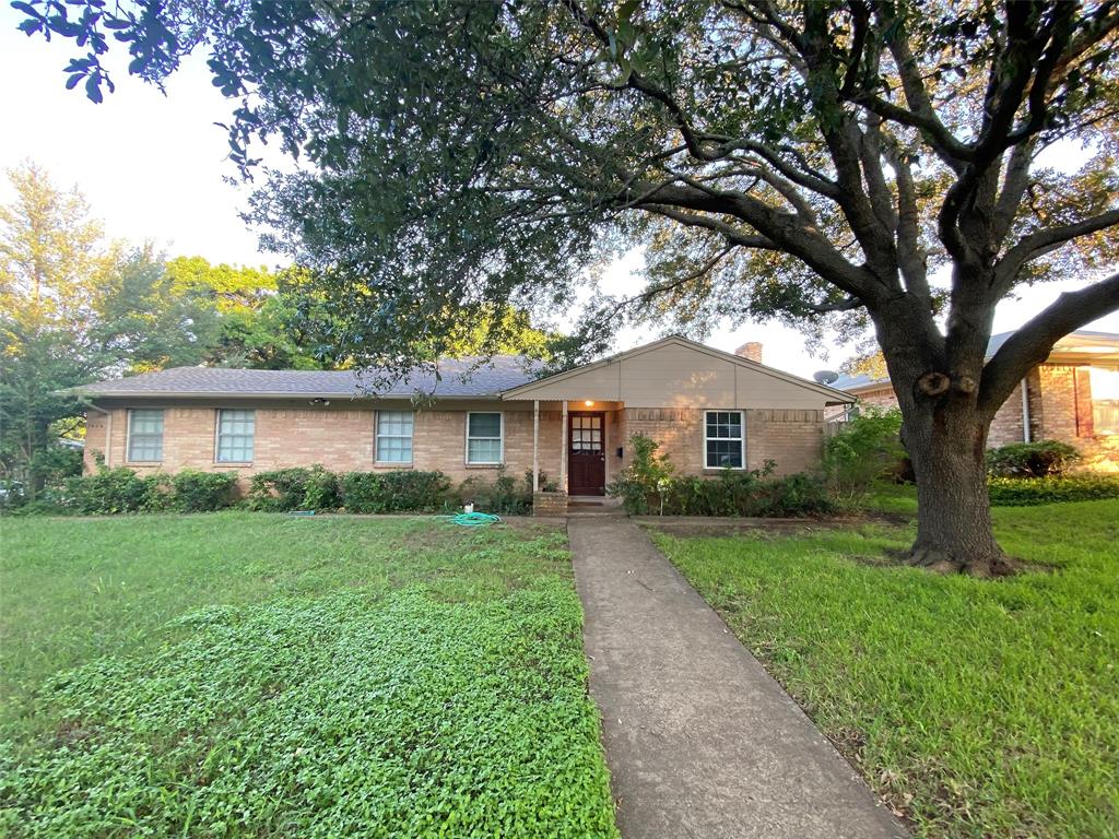 a front view of a house with yard and green space