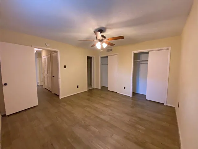 a view of a room with a ceiling fan and a window