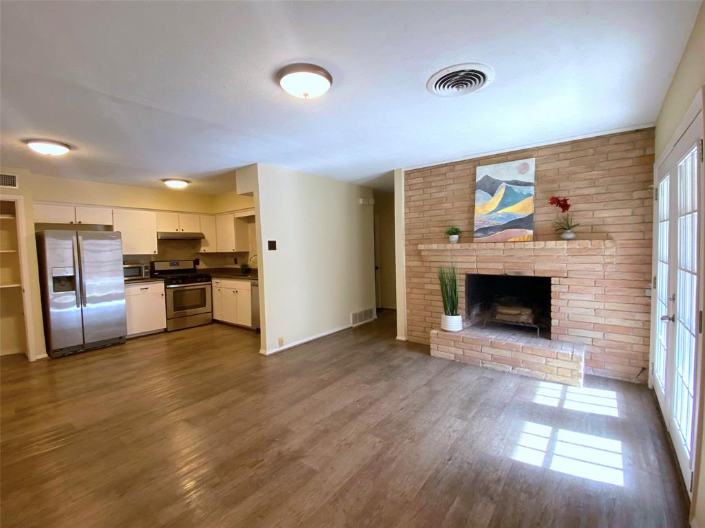 7406 Walling Lane Dallas, TX 75231 - Photo 3 of 15 a view of a hallway with a kitchen and a fireplace